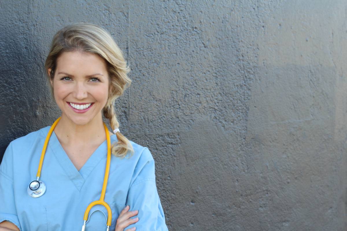 Young nurse in blue scrubs with a yellow stethoscope